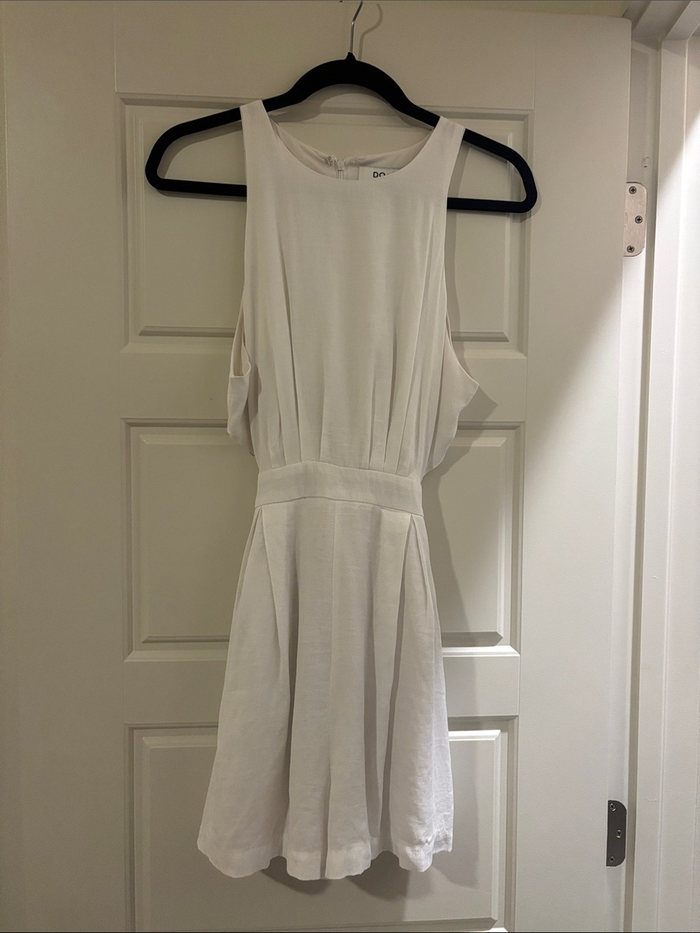 White Sleeveless romper with cut out sides and tie/bow in the back